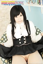 Erena Naitou seated on chair lifting her dress up over her shaved pussy