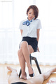 Ayumi kuroki sitting on stool short hair in uniform short skirt wearing high heels