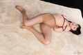 Lying on her back arms bound wearing pantyhose